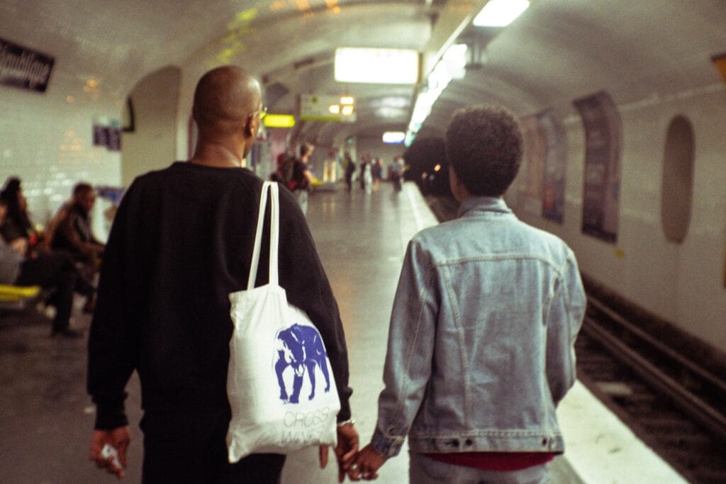 Two people walking down a tube station platform, with their backs to the camera